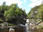 A team cross the suspension bridge at the Falls of Tarf