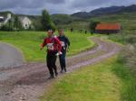 A team run through the hamlet of Achintree after the last control