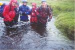 Three teams linked arms for safety to crossing the River Meig in Gleann Fhiodhaig at 141484 to get to Checkpoint 3 on the D course, early Saturday afternoon