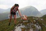 A competitor on the A course punches her third control having come from the far side of Beinn Chasteil , which looms behind her